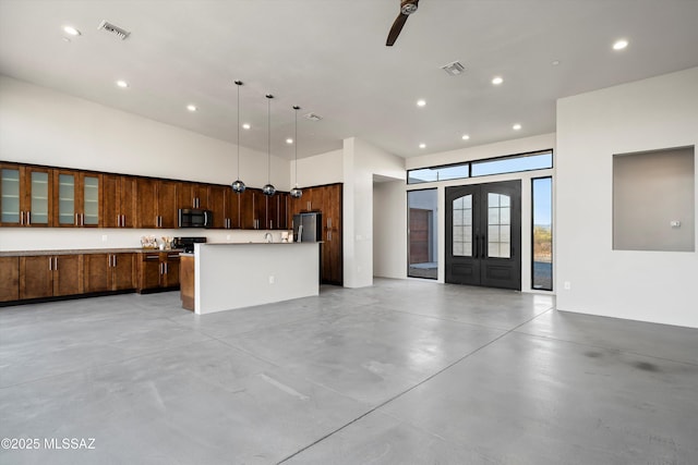 kitchen featuring visible vents, concrete flooring, open floor plan, and freestanding refrigerator