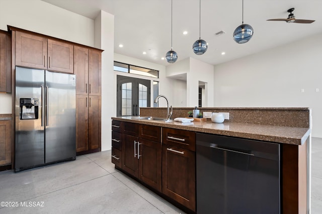 kitchen featuring decorative light fixtures, an island with sink, french doors, stainless steel appliances, and a sink