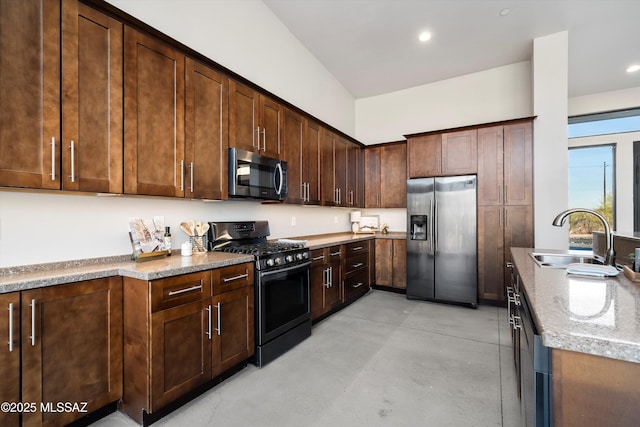 kitchen featuring dark brown cabinetry, concrete flooring, recessed lighting, stainless steel appliances, and a sink