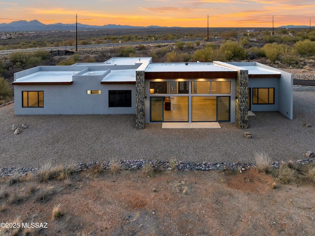 rear view of house featuring a mountain view and stucco siding