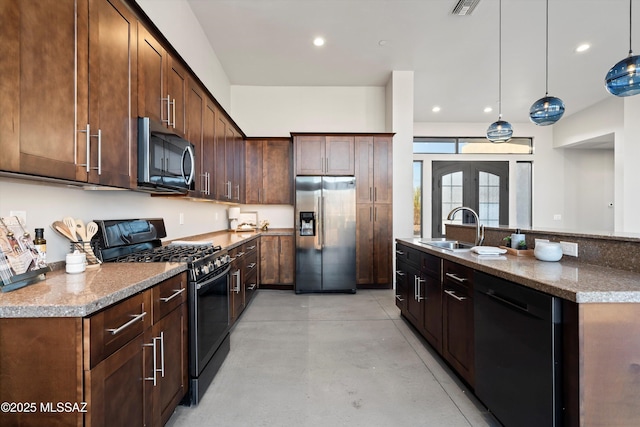 kitchen with decorative light fixtures, recessed lighting, french doors, black appliances, and a sink