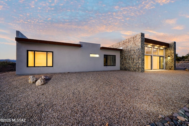 rear view of house with stucco siding