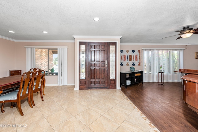 foyer entrance with crown molding and a wealth of natural light