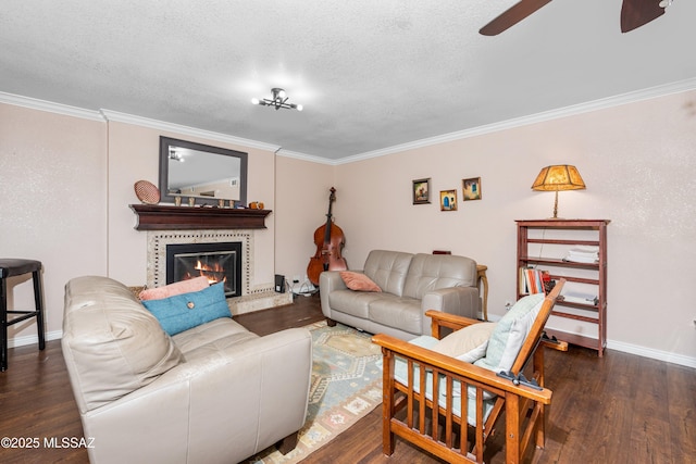 living area featuring wood finished floors, crown molding, a ceiling fan, and a textured ceiling