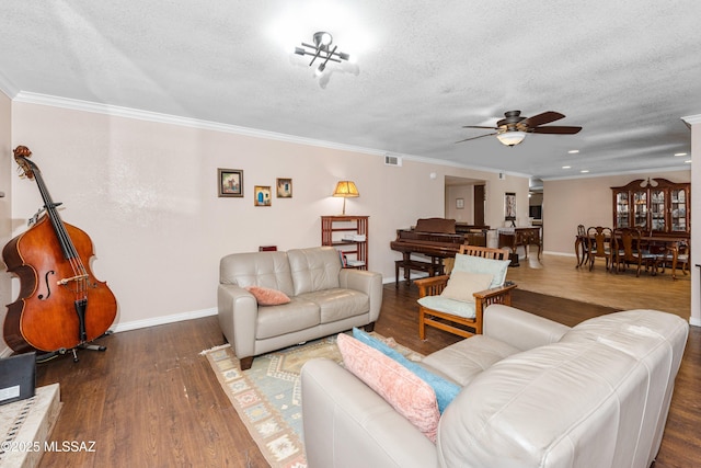 living area featuring a textured ceiling, crown molding, baseboards, and wood finished floors