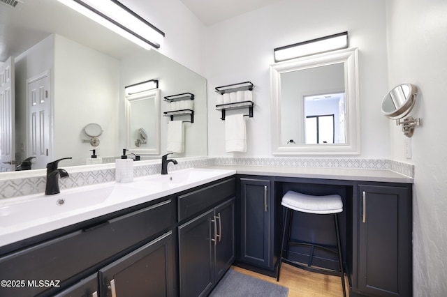 full bath featuring double vanity, wood finished floors, a sink, and visible vents