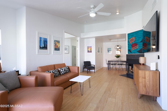 living area with a ceiling fan and light wood-type flooring