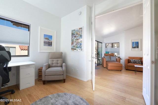 office space featuring lofted ceiling, light wood finished floors, and baseboards