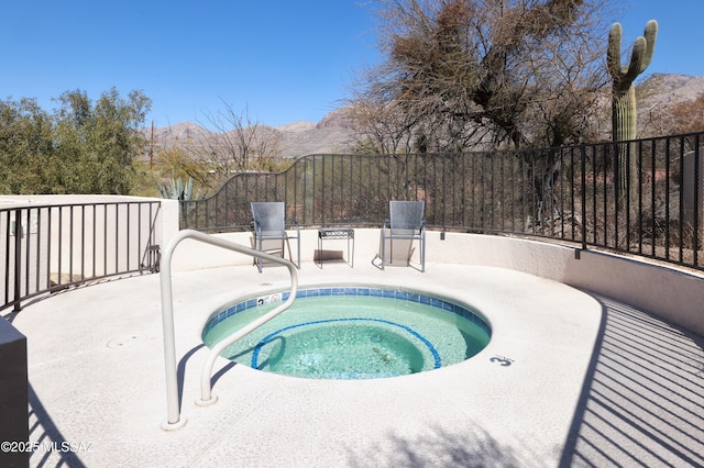 view of pool with a community hot tub, a patio, fence, and a mountain view