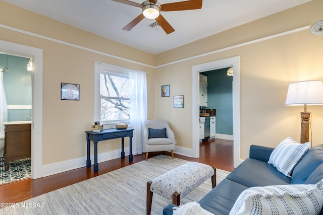 living room with wood finished floors, visible vents, and baseboards