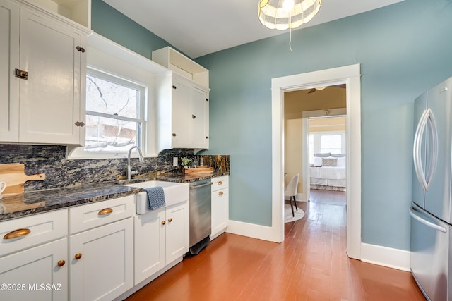 kitchen with stainless steel appliances, white cabinets, and a sink