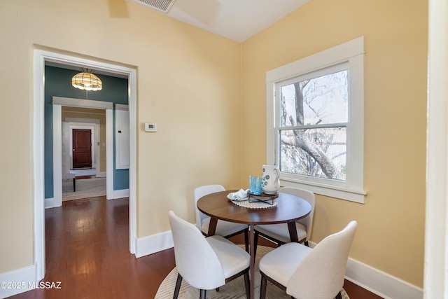 dining room featuring baseboards and dark wood-style flooring