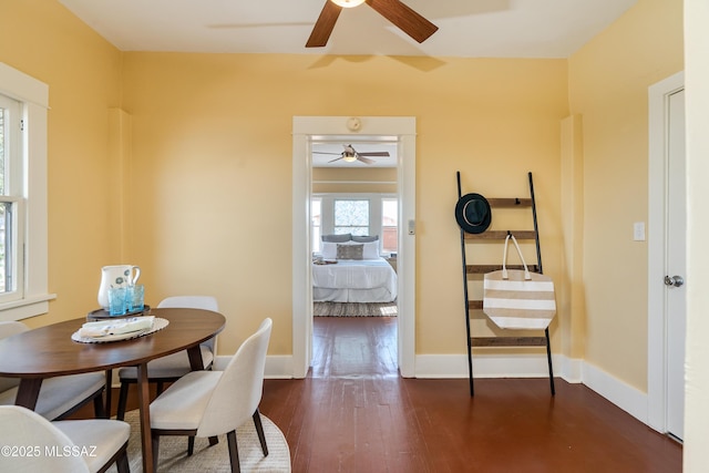 dining area with dark wood-type flooring and baseboards