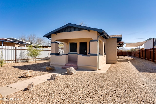 view of front of property with a fenced backyard and stucco siding