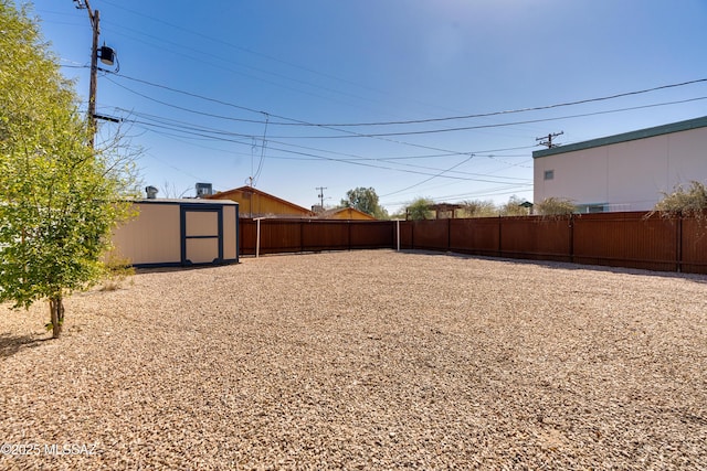 view of yard featuring a shed, a fenced backyard, and an outdoor structure