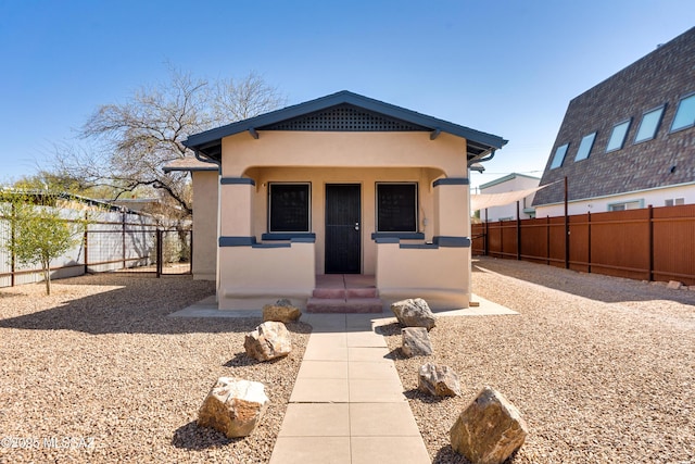 view of front facade featuring a fenced backyard and stucco siding