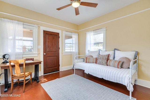 living area with a ceiling fan, baseboards, and wood finished floors