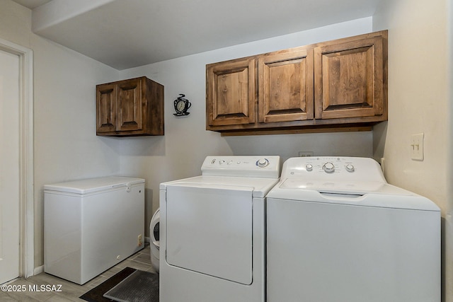 clothes washing area with washing machine and clothes dryer and cabinet space