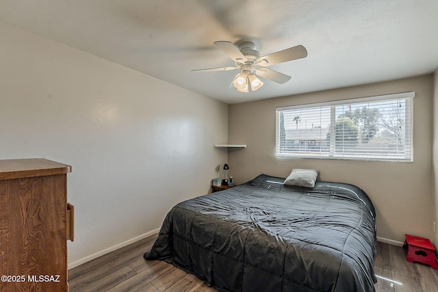 bedroom with ceiling fan, baseboards, and wood finished floors