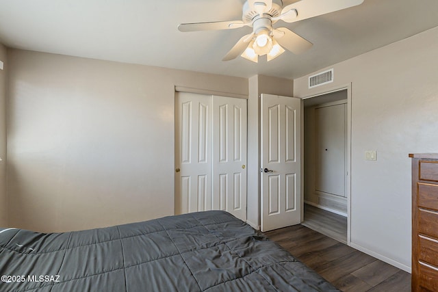 unfurnished bedroom with visible vents, baseboards, a ceiling fan, a closet, and dark wood-style floors