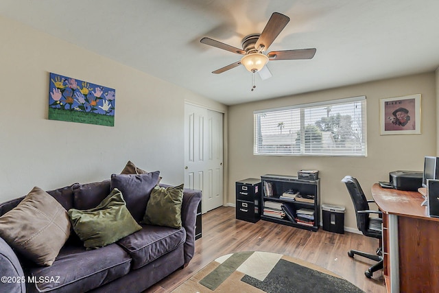 office area featuring a ceiling fan, baseboards, and wood finished floors