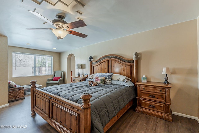 bedroom featuring arched walkways, ceiling fan, dark wood-style flooring, and baseboards