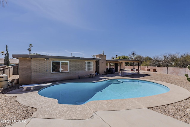 view of pool with a fenced in pool, a patio area, a fenced backyard, and a diving board