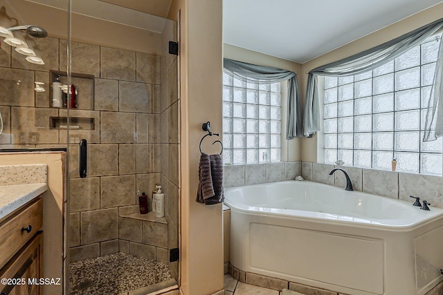 full bathroom featuring a garden tub, a shower stall, and vanity