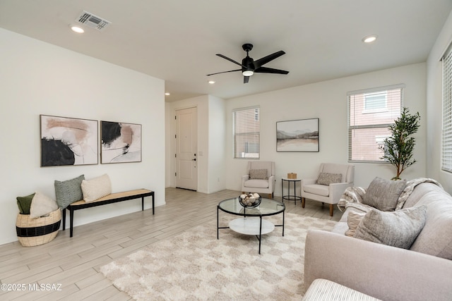 living room with a ceiling fan, visible vents, wood finished floors, and recessed lighting