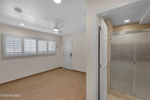 interior space featuring a stall shower, baseboards, a ceiling fan, wood finished floors, and recessed lighting