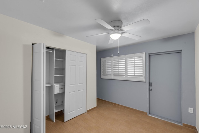 unfurnished bedroom featuring ceiling fan, a closet, and light wood-type flooring