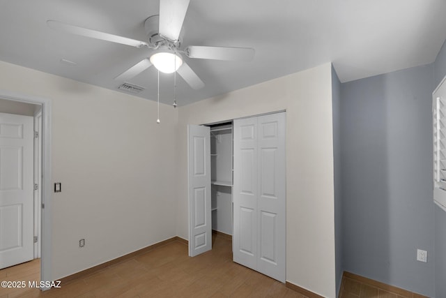 unfurnished bedroom featuring baseboards, visible vents, ceiling fan, light wood-type flooring, and a closet