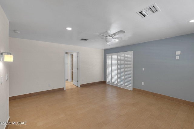 empty room with light wood-style flooring, visible vents, ceiling fan, and baseboards