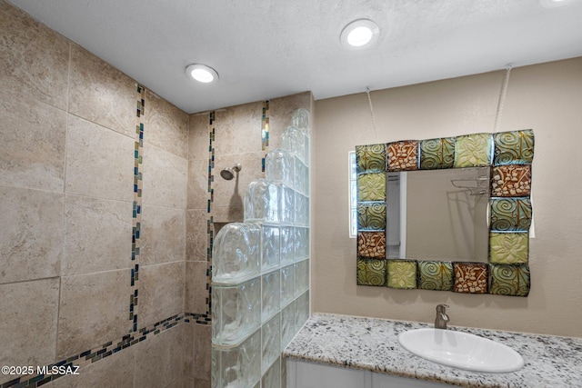 bathroom with recessed lighting, vanity, and a walk in shower