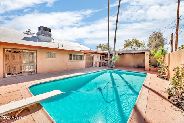 view of pool featuring a fenced in pool, central air condition unit, a patio area, a fenced backyard, and a diving board