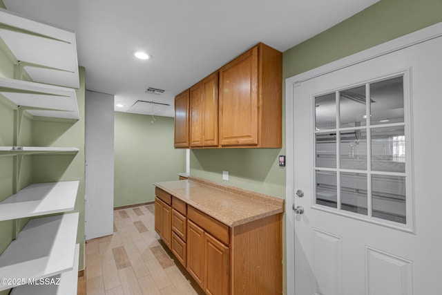 interior space featuring light wood-style flooring, recessed lighting, visible vents, light countertops, and brown cabinets