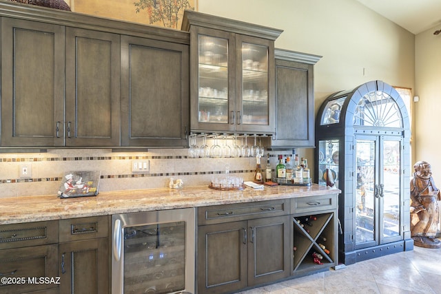 bar featuring tasteful backsplash, wine cooler, a dry bar, and light tile patterned floors