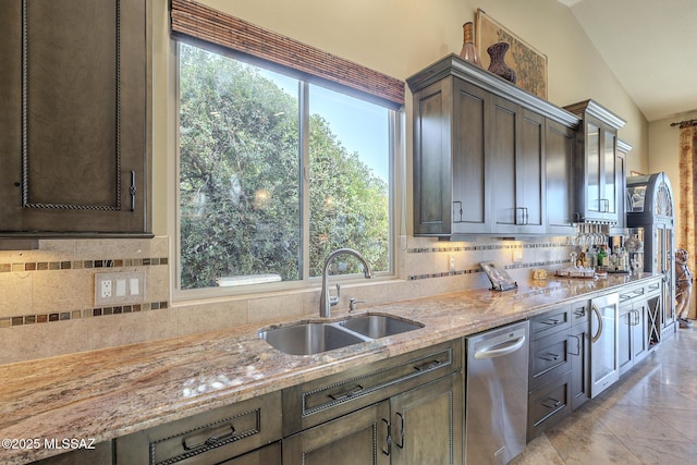 kitchen with dark brown cabinets, light stone counters, backsplash, and a sink