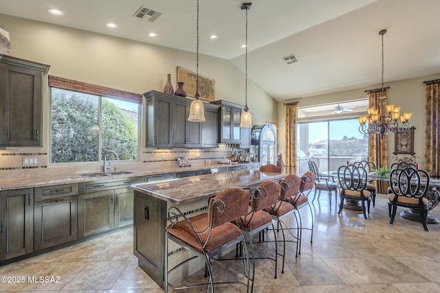 kitchen with light stone countertops, visible vents, and a sink