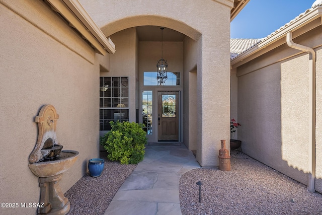 doorway to property featuring a tile roof and stucco siding