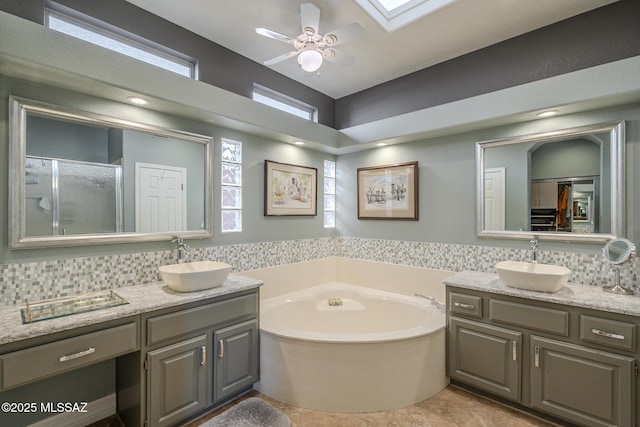 full bathroom with a garden tub, two vanities, and a sink