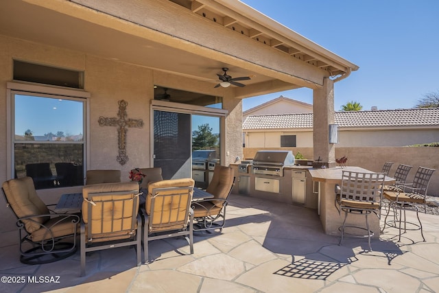 view of patio / terrace featuring exterior kitchen, outdoor dining space, a grill, and a ceiling fan