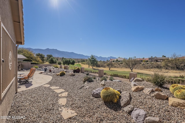 view of yard with a patio area, fence, and a mountain view