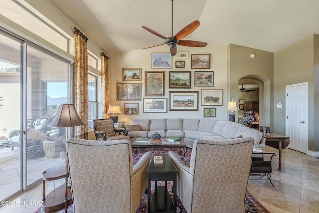 living room with arched walkways, lofted ceiling, and a ceiling fan