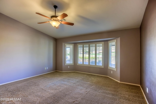 carpeted spare room with lofted ceiling, ceiling fan, and baseboards