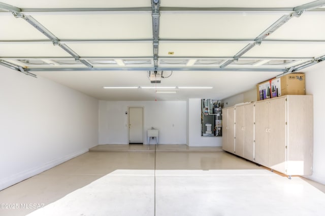 garage with secured water heater, a sink, and a garage door opener