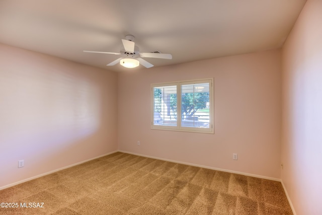 spare room with ceiling fan, baseboards, and light colored carpet