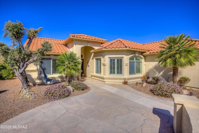 exterior space with a tile roof and stucco siding