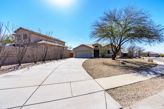 view of front of home featuring driveway, a garage, fence, and stucco siding