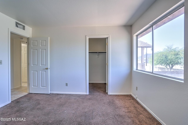 3381 W Calle De La Bajada, Tucson, AZ 85746 - unfurnished bedroom with multiple windows, carpet, a spacious closet, and baseboards